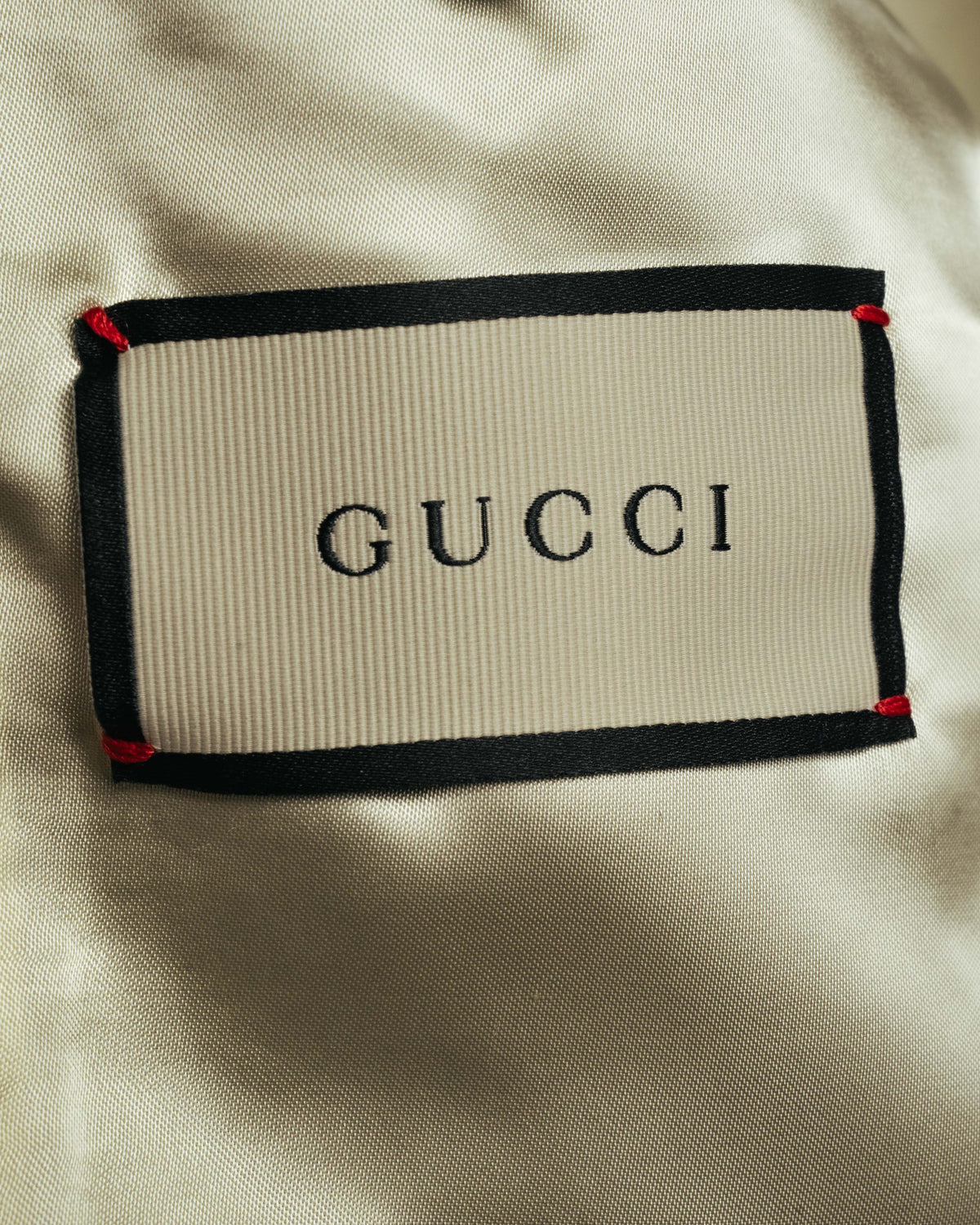 黄みを含んだアイボリーからシャンパンを思わせる総裏地に配された、GUCCIロゴ入りの内タグ。