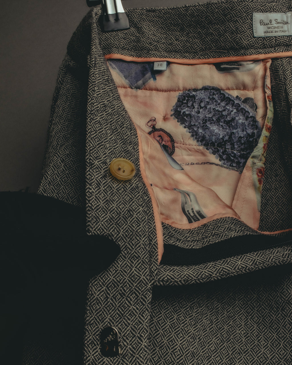 ウエスト内側に付く「Paul Smith WOMEN MADE IN ITALY」の織りネームと、独立した38表記のサイズタグを捉えたカット。サーモンピンクから淡いコーラル系のアート調ポケット布と、同系色のパイピングも確認できます。