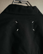 ブラックの背面ネック下に配された、4本の白いステッチを捉えたディテールカット。シャツカラー下のヨーク切り替えとあわせて確認できます。