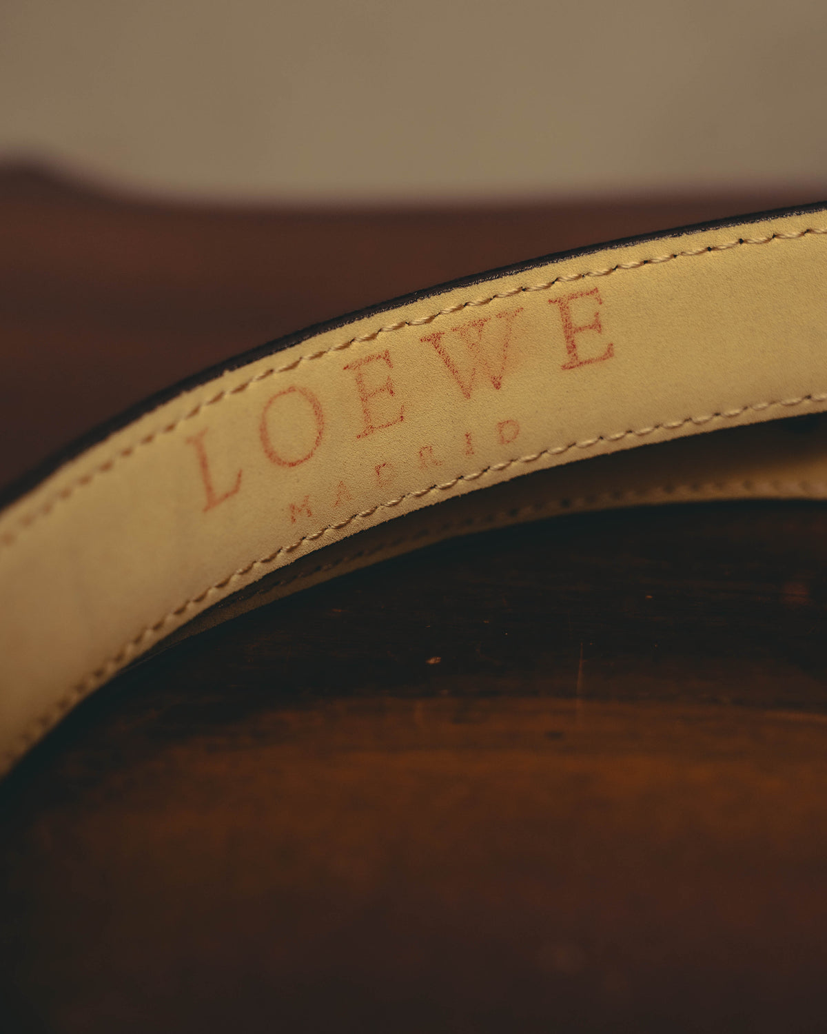 ベージュカラーのレザーを用いた裏面に、セリフを備えたLOEWEの表記が確認できるタグカット。縁には細やかなステッチが施されています。