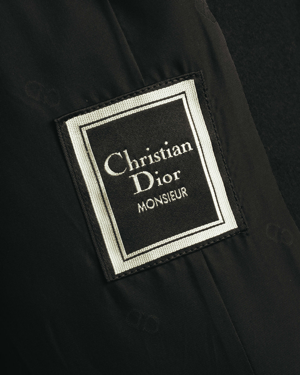 内側に配されたChristian Dior MONSIEURの織りネームを捉えたカット。ブラックの裏地とともに、当時のメンズラインの仕様を確認できます。