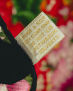 生成り色の織りタグに、GUCCI、100% SILK、SOIE、MADE IN ITALYおよび法令表記が確認できるタグのクローズアップ。