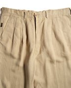 ウエスト周りに施された深めの2タックと、サイドポケット横の小ぶりな「i Pants」タブを捉えたディテールカット。ライトベージュのリネンブレンド生地の織り感も確認できます。