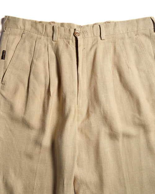 ウエスト周りに施された深めの2タックと、サイドポケット横の小ぶりな「i Pants」タブを捉えたディテールカット。ライトベージュのリネンブレンド生地の織り感も確認できます。