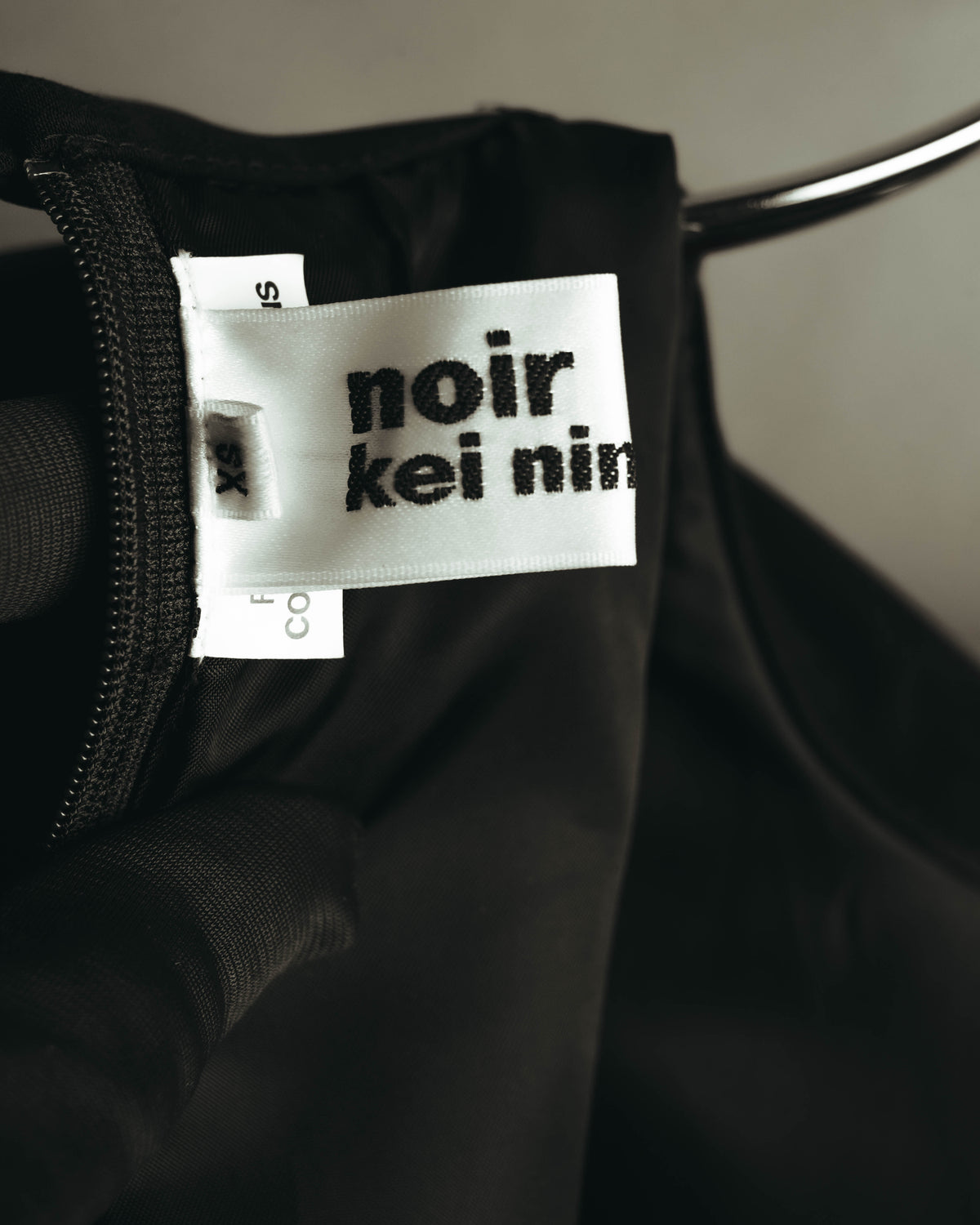 裏地側に配されたブランドネームタグと、XS表記のサイズタグを確認できる内側のタグカット。