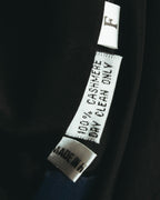 裏地内側に配された品質表示タグのクローズアップ。CASHMERE 100%およびMADE IN H.K.の表記が確認できるカット。
