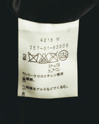 内側に配された洗濯表示タグのカット。ドライクリーニング指定やスチーム可、パークロロエチレン使用の石油系溶剤による洗濯表示を確認できます。