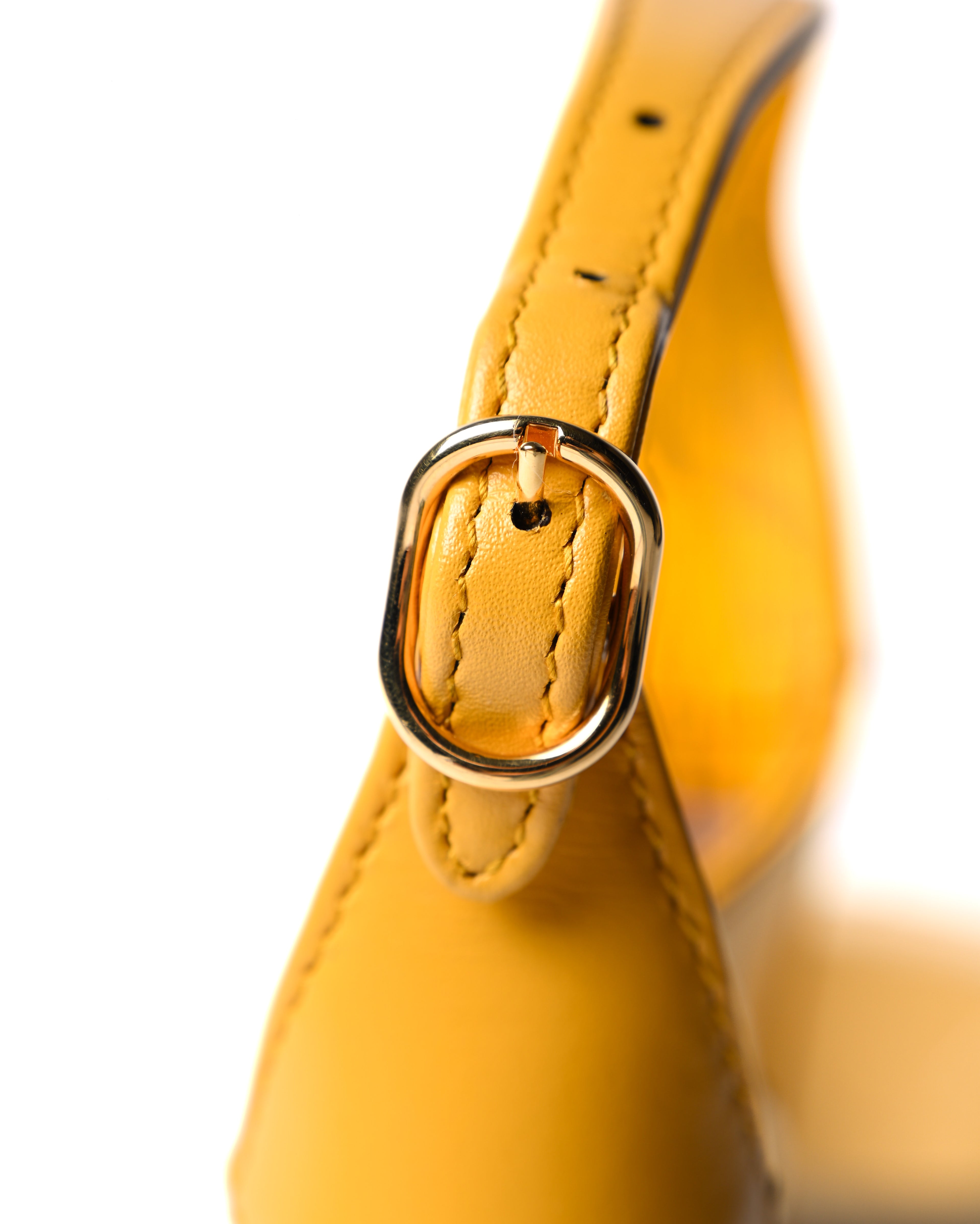 イエローレザーのトップハンドル根元に配された、ゴールドメタルのハトメと丁寧なステッチワークを捉えたディテールカット。