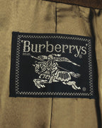 内側に配された、黒地に旧表記のBurberrys'と騎馬騎士図案を織り込んだ主タグのクローズアップ。キュプラ裏地の上に縫い付けられています。