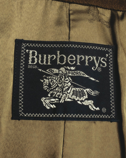 内側に配された、黒地に旧表記のBurberrys'と騎馬騎士図案を織り込んだ主タグのクローズアップ。キュプラ裏地の上に縫い付けられています。