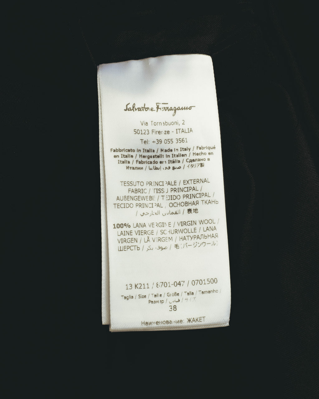 旧署名体のSalvatore Ferragamoロゴと、多言語で記載された品質表示を確認できる内タグ。表地ヴァージンウール100%およびサイズ38表記が読み取れるカット。