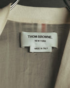襟元に配されたTHOM BROWNE NEW YORK表記のブランドタグ。背裏にはレッド、ホワイト、ネイビーのトリコロールが縦に走ります。