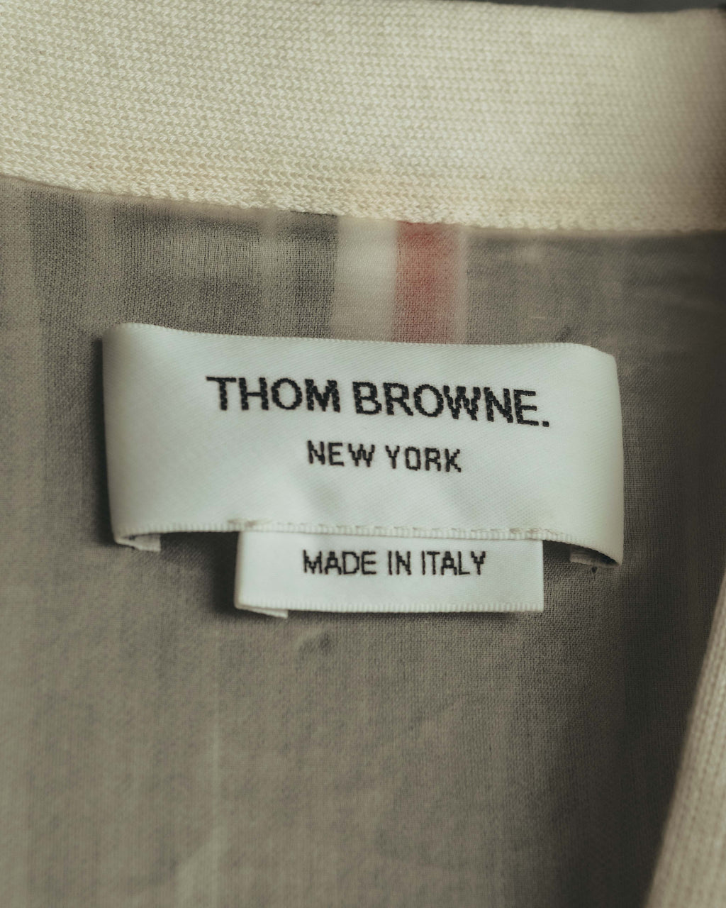 首元に配された「THOM BROWNE. NEW YORK」表記のブランドタグと、「MADE IN ITALY」表記の原産国タグ。背面にはトリコロールのラインが見える。