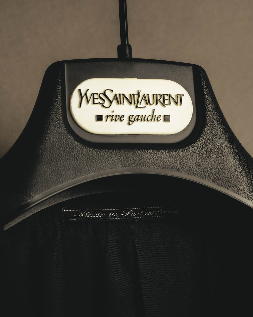 白いサテン織りの Yves Saint Laurent rive gauche タグと、襟元に残る Made in Switzerland 表記を捉えたカット。