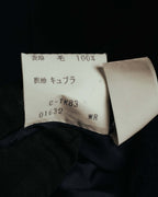 表地「毛 100%」と裏地「キュプラ」、製品コードが記載された日本語の品質表示タグ。総裏仕立ての内側に残る旧式の表記を確認できるカットです。