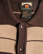 襟元のネックラベルと、サイズ1XL・綿60％／アクリル40％表記の品質表示タグを捉えたカット。フルボタン仕様の前立てにはFB COUNTY刻印入りボタンを配しています。