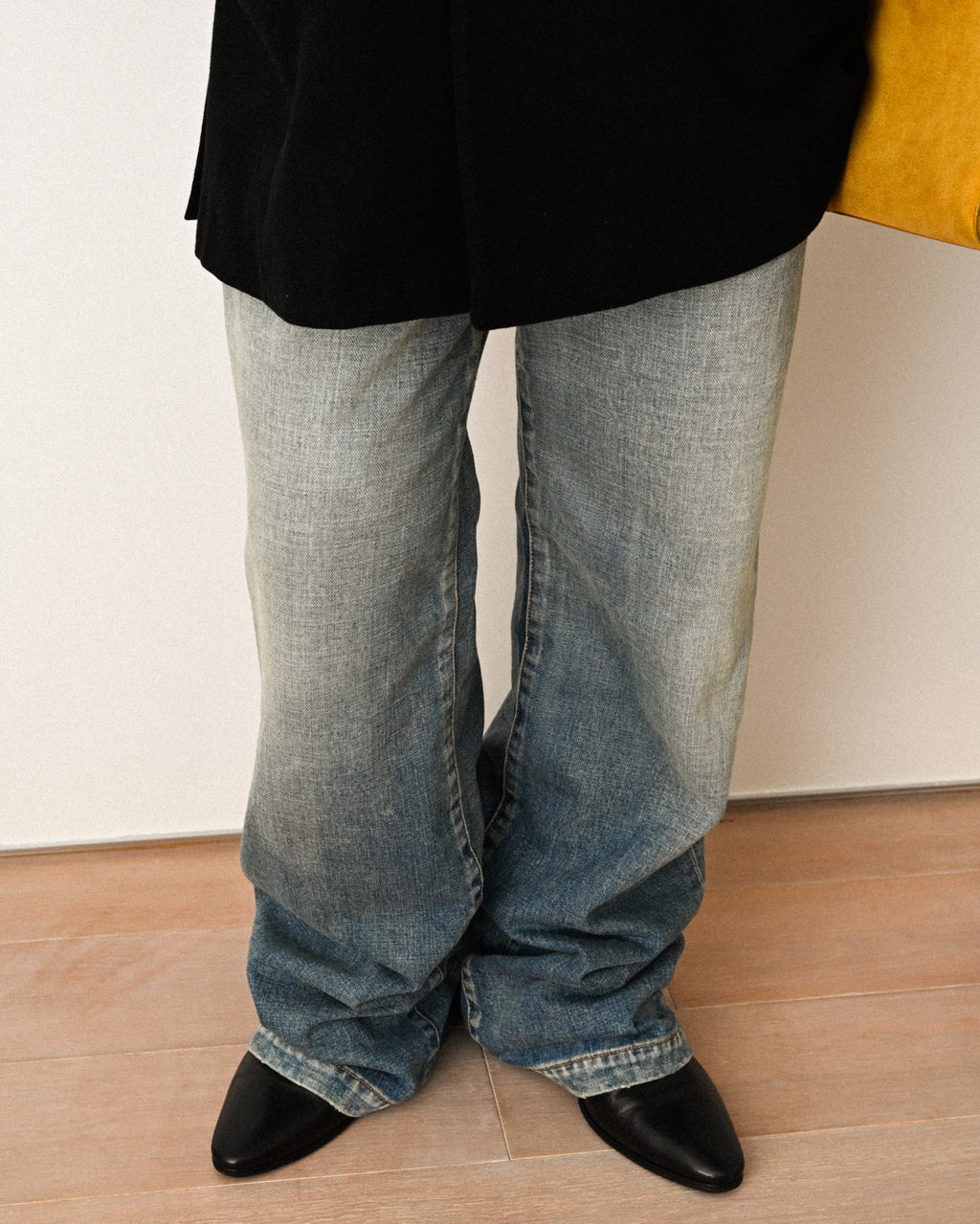ワイドストレートのシルエットと、足元にクッションを持たせた裾の落ち感が分かる着用カット。フェード感のあるブルーデニムをブラックのレザーシューズと合わせています。