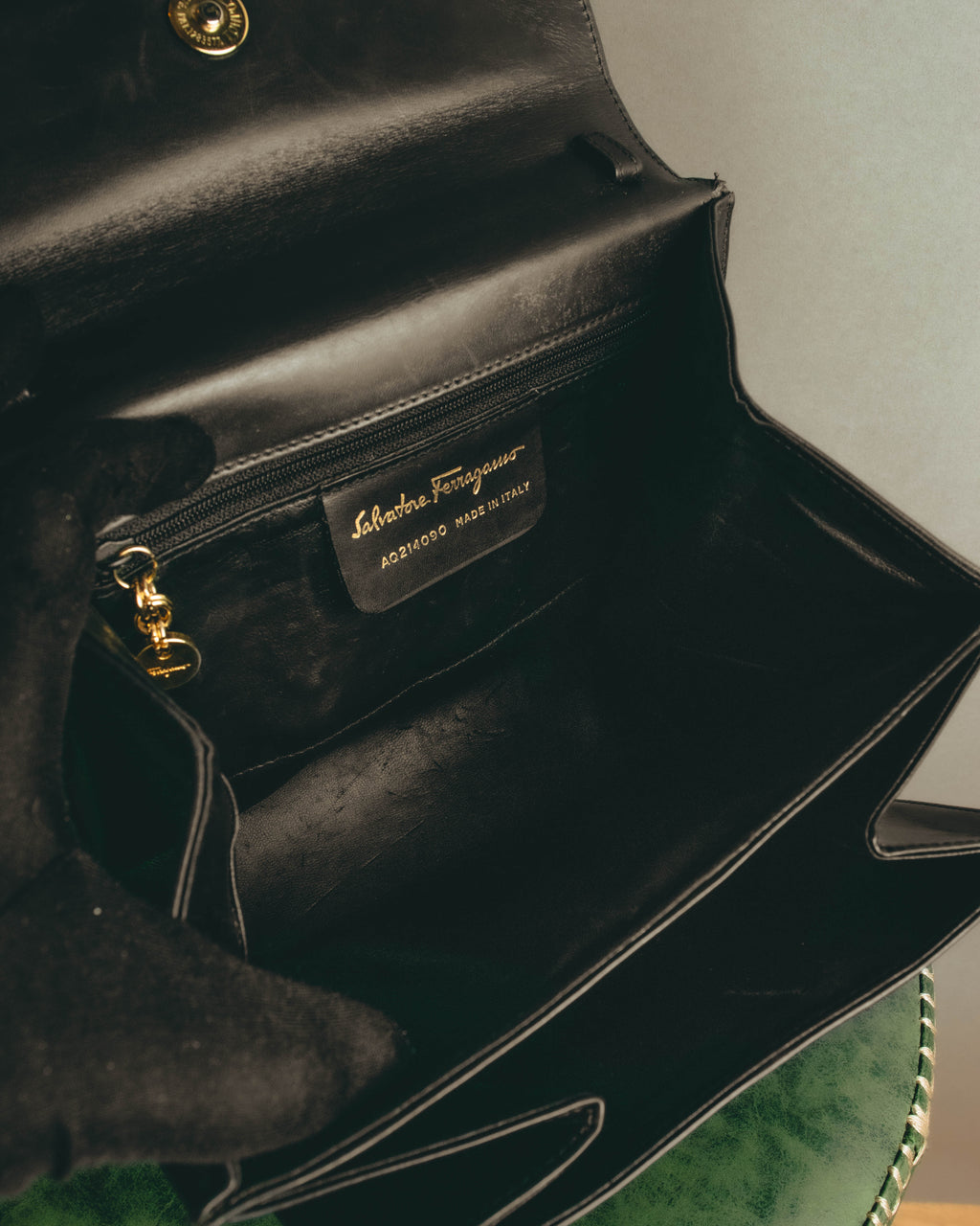 内装のファスナーポケット脇に配された、Salvatore Ferragamoおよび品番表記の革製パッチ。ゴールドカラーのファスナーチャームも確認できる内装ディテールです。