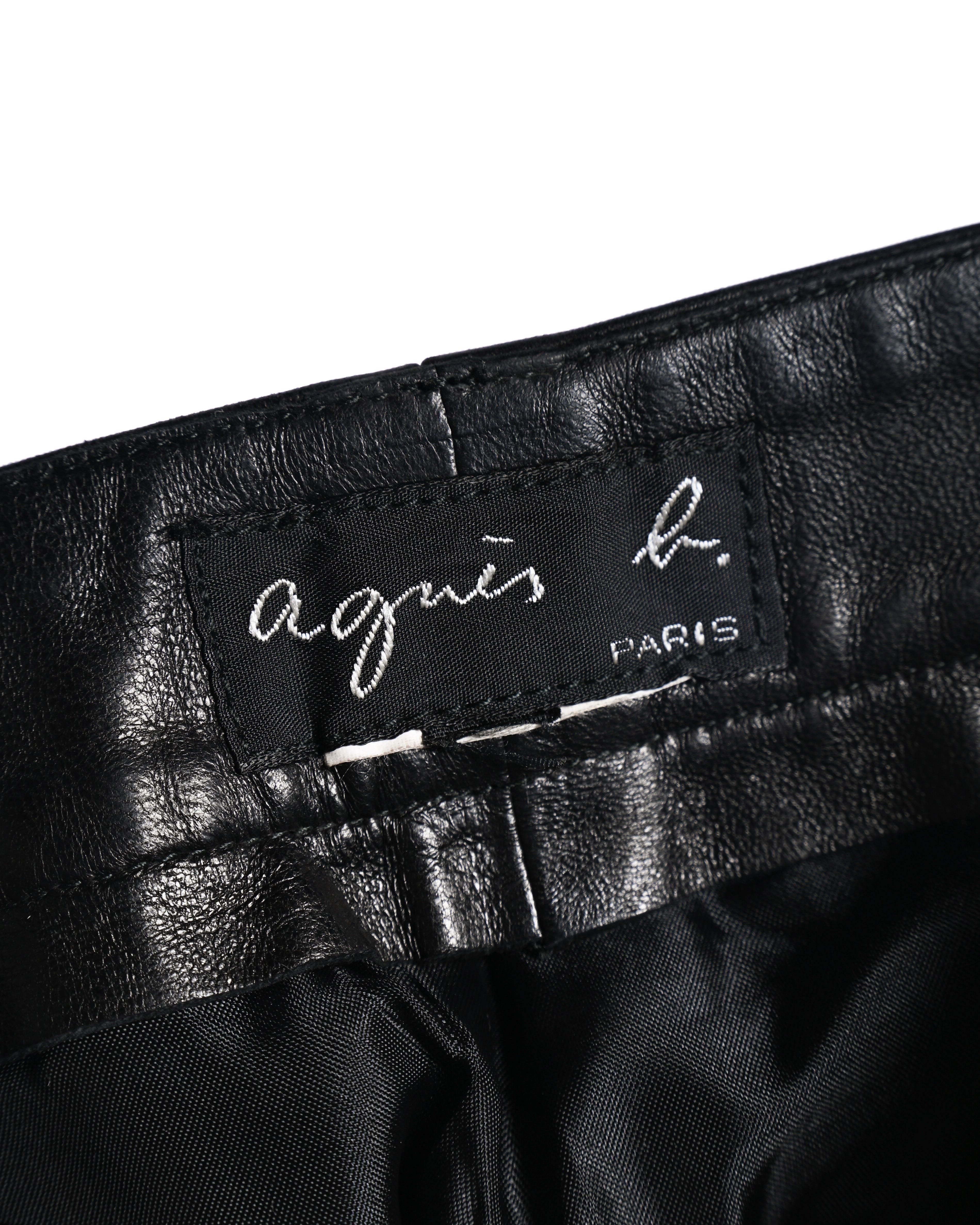 ウエスト内側に縫い付けられた「agnès b. PARIS」表記のブランドタグ。ブラックレザーの裏側とライニングの質感も確認できるカット。