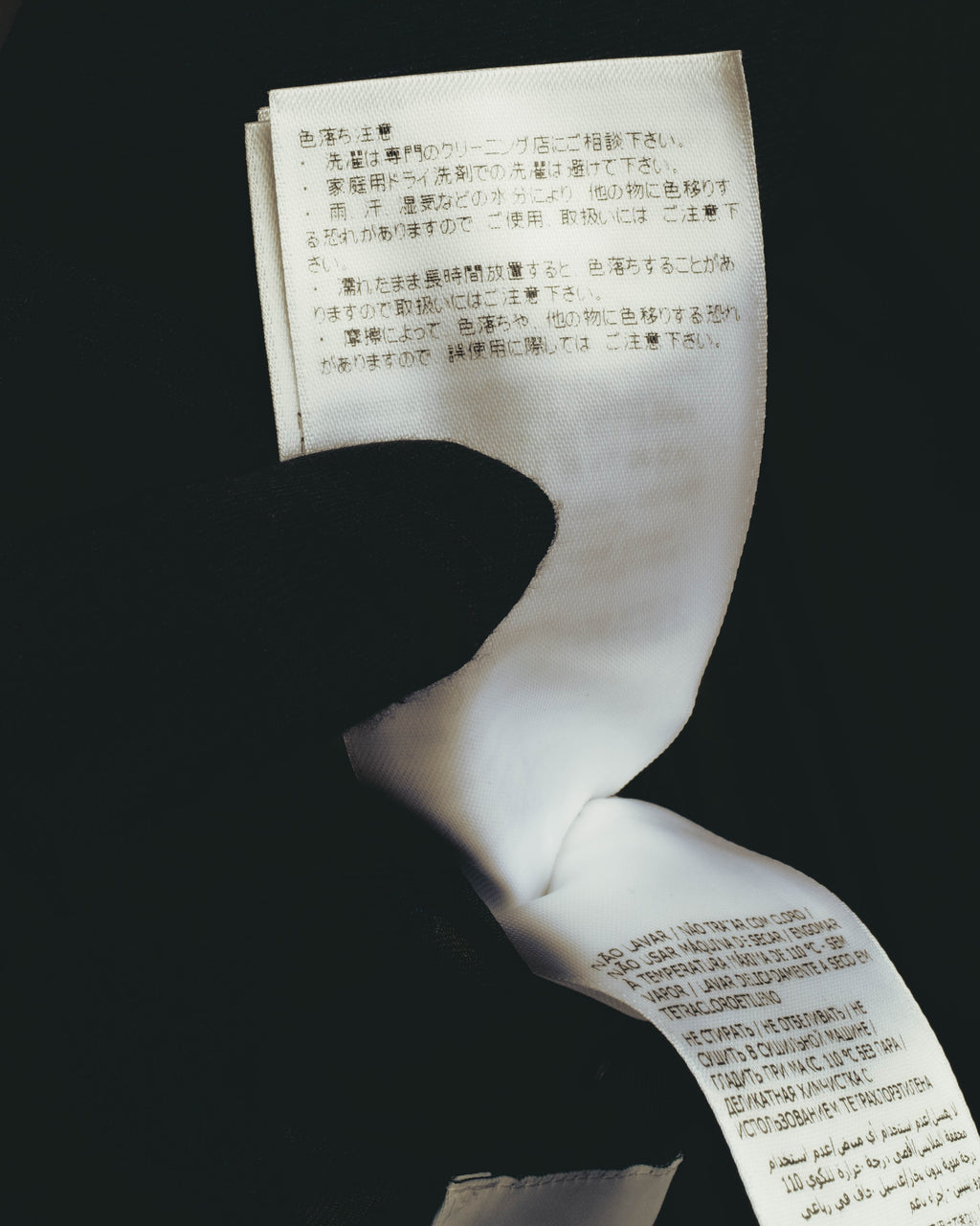 日本語表記と多言語表記を備えた、ジャケット内側の品質表示タグのクローズアップ。旧署名体ロゴ期に見られる現代的な多言語品質表示を確認できるカット。