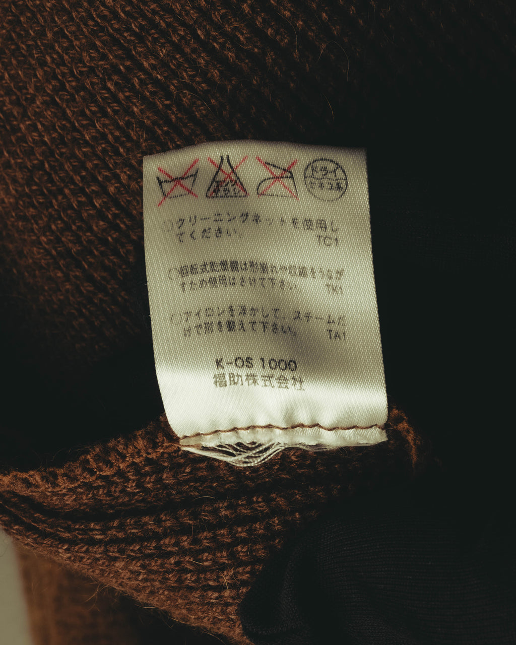 ニット内側に縫い付けられた、洗濯表示と福助株式会社の表記を確認できる品質表示タグ。