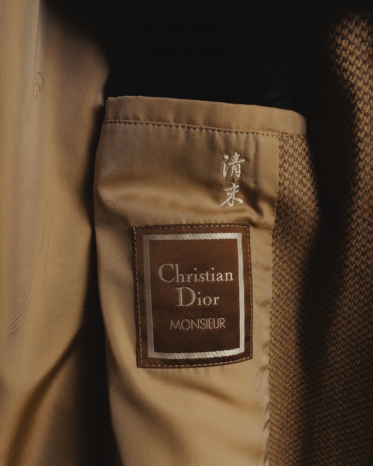 内側に配されたChristian Dior Monsieurの織りラベルと、その上に残るネーム刺繍を捉えたカット。滑らかな総柄裏地と表地の二色織りも確認できます。