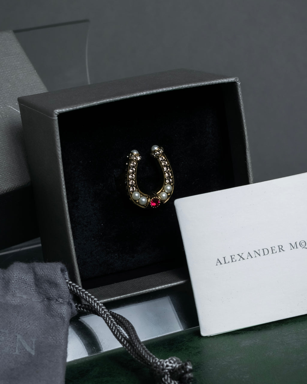 "Alexandar McQueen" Horseshoe motif red stone top ring