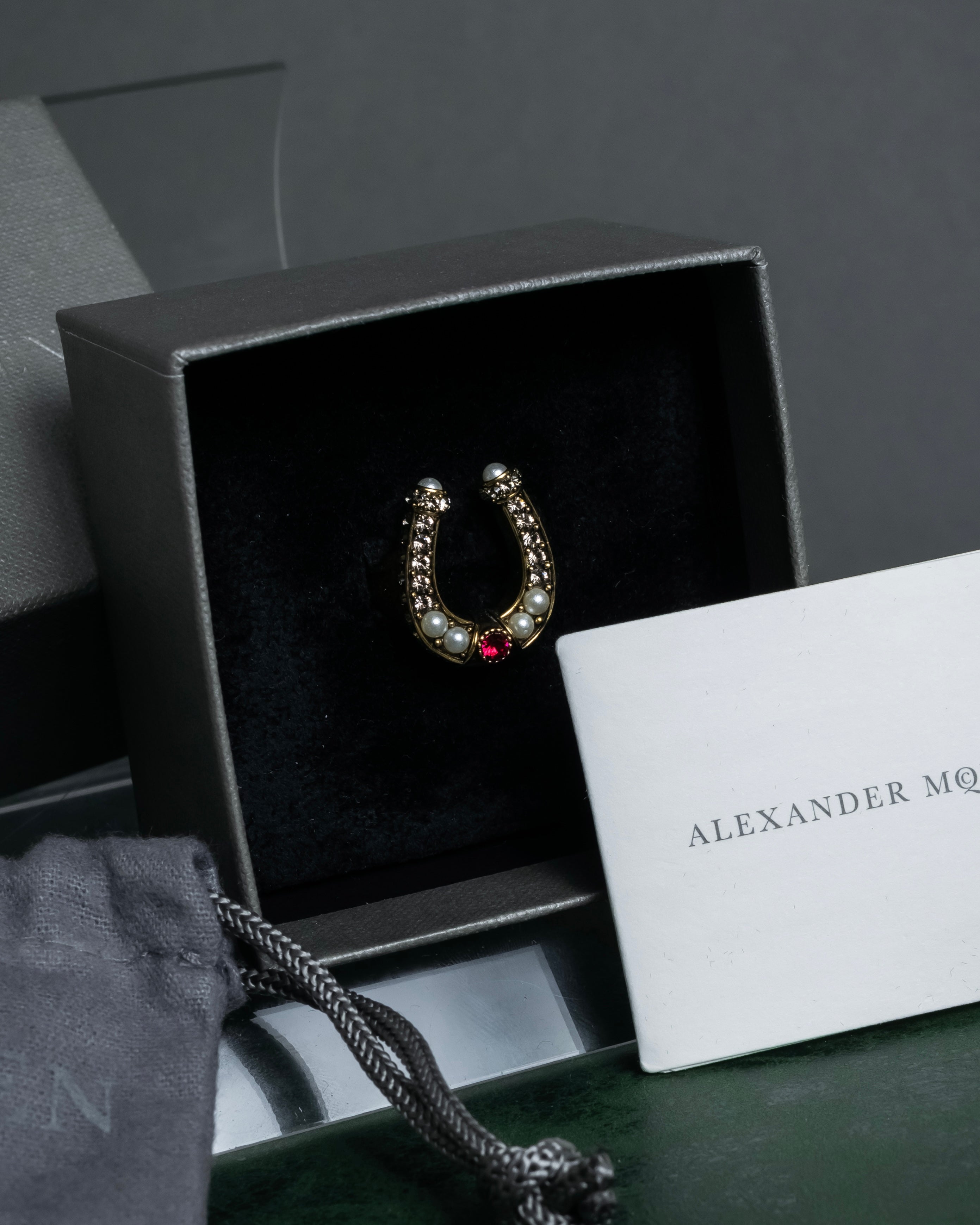 "Alexandar McQueen" Horseshoe motif red stone top ring