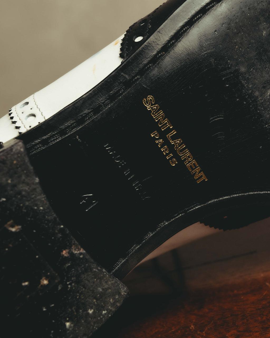 ブラックのインソールに、ゴールドカラーでSAINT LAURENT PARISのロゴが入る内側のディテールカット。履き口付近にはブラックとホワイトのレザーパネルおよびブローギングも確認できます。
