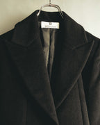大ぶりのノッチドラペルと、首元に残るBOUTIQUES GIVENCHYの織りタグを捉えた上半身のディテールカット。起毛したブラック系ウール地と内側の総裏地も確認できます。
