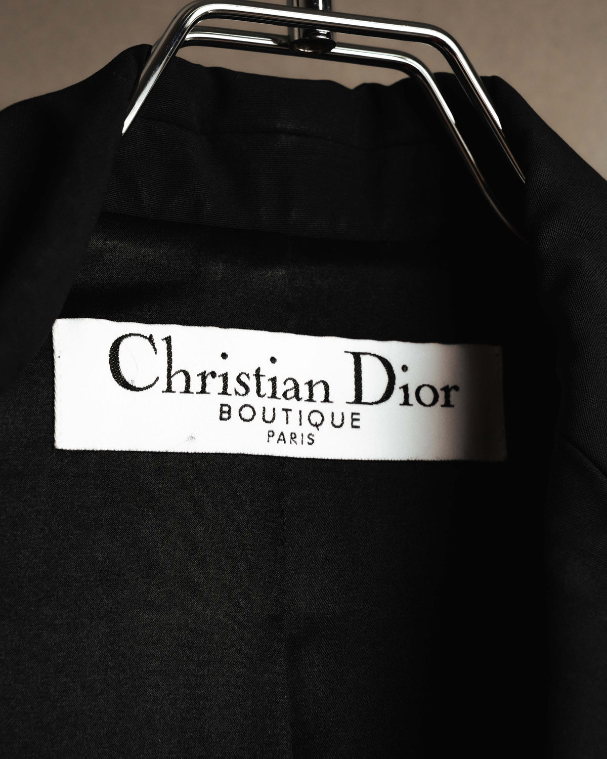 襟元に備わる「Christian Dior BOUTIQUE PARIS」表記の織りタグを捉えたカット。