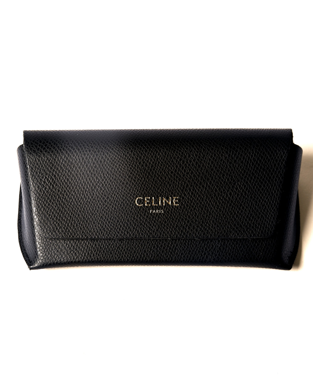 付属するシボ革仕様のブラックレザーケースを正面から捉えたカット。フラップ中央に「CELINE PARIS」のロゴが配されています。