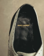シューズ内側のブラックインソールに、ゴールドカラーでSAINT LAURENT PARISのロゴが入るカット。履き口周囲にはホワイトレザーとブローギングも確認できます。