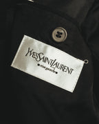 内側に配された白いサテン織りの「Yves Saint Laurent rive gauche」タグを捉えたカット。タグ上部には4つ穴のボタンとブラックの裏地が見える。