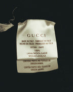 GUCCIロゴ、イタリア製表記、品番「327504 - Z6693」とウール100％の素材表記が確認できる内タグのカット。