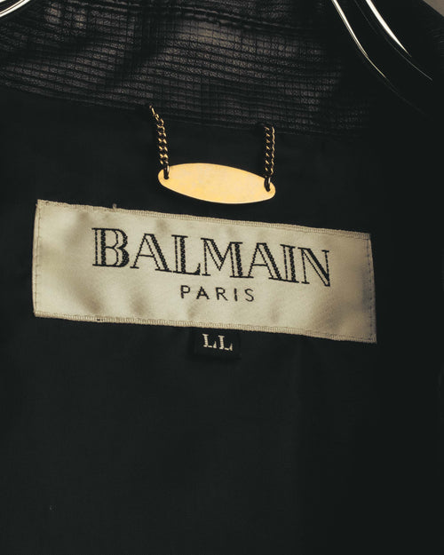 ブラックの裏地に配されたBALMAIN PARISの内タグと、LL表記のサイズタグ。上部にはチェーンで留められた金色のプレートが確認できます。