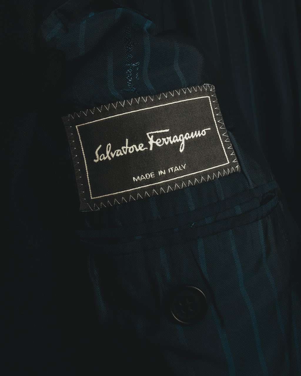 内側に配されたSalvatore Ferragamoのブランドネームタグ。MADE IN ITALY表記と、青緑を帯びたダークトーンのストライプ裏地を確認できるカット。