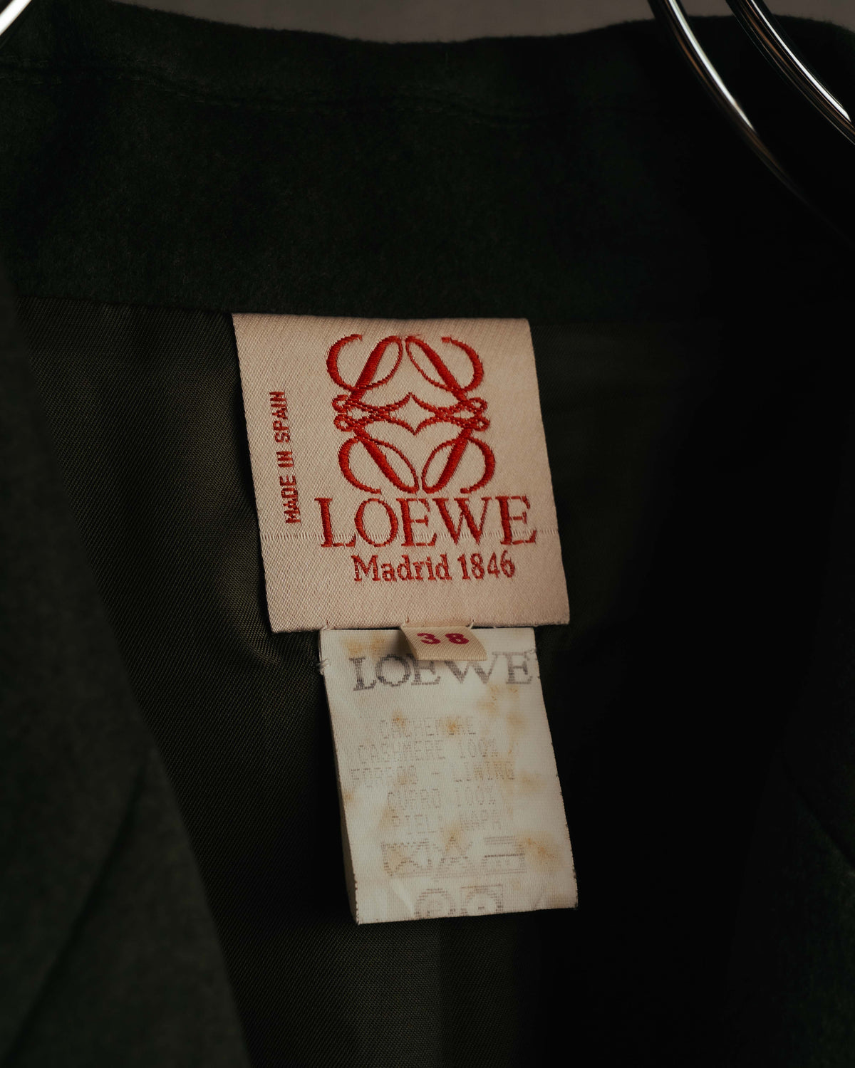 生成り地に赤色の旧型アナグラム、LOEWE、Madrid 1846を織り出した首元タグ。下部には独立したサイズ38タグと、退色した品質表示タグが確認できます。