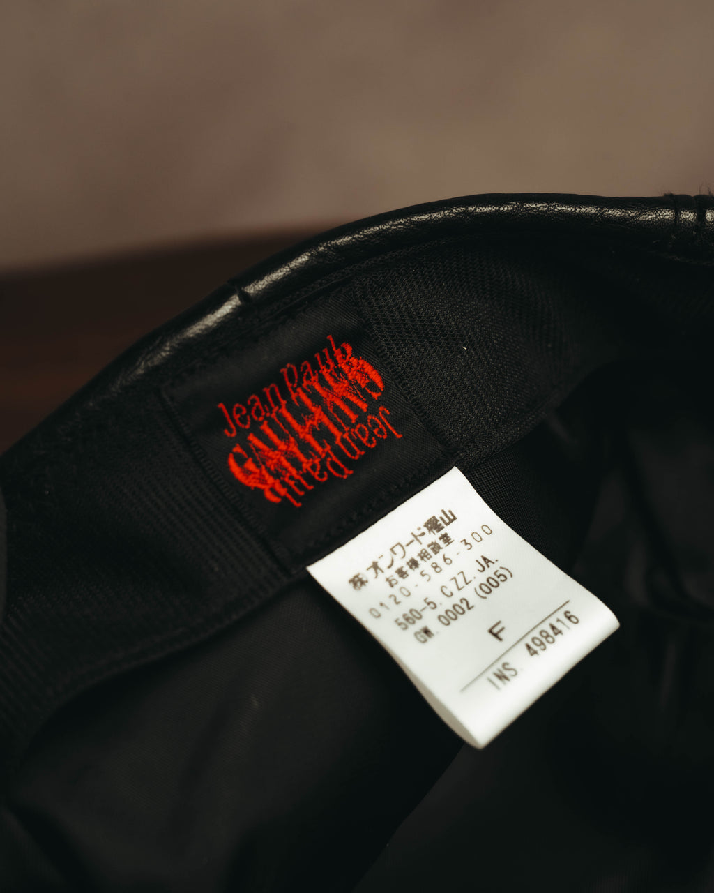 内側の汗止め部分に配された、赤色ロゴを織り込んだJean Paul GAULTIER fitted wearタグと、オンワード樫山による国内ライセンス表示タグのカット。サイズはF表記。