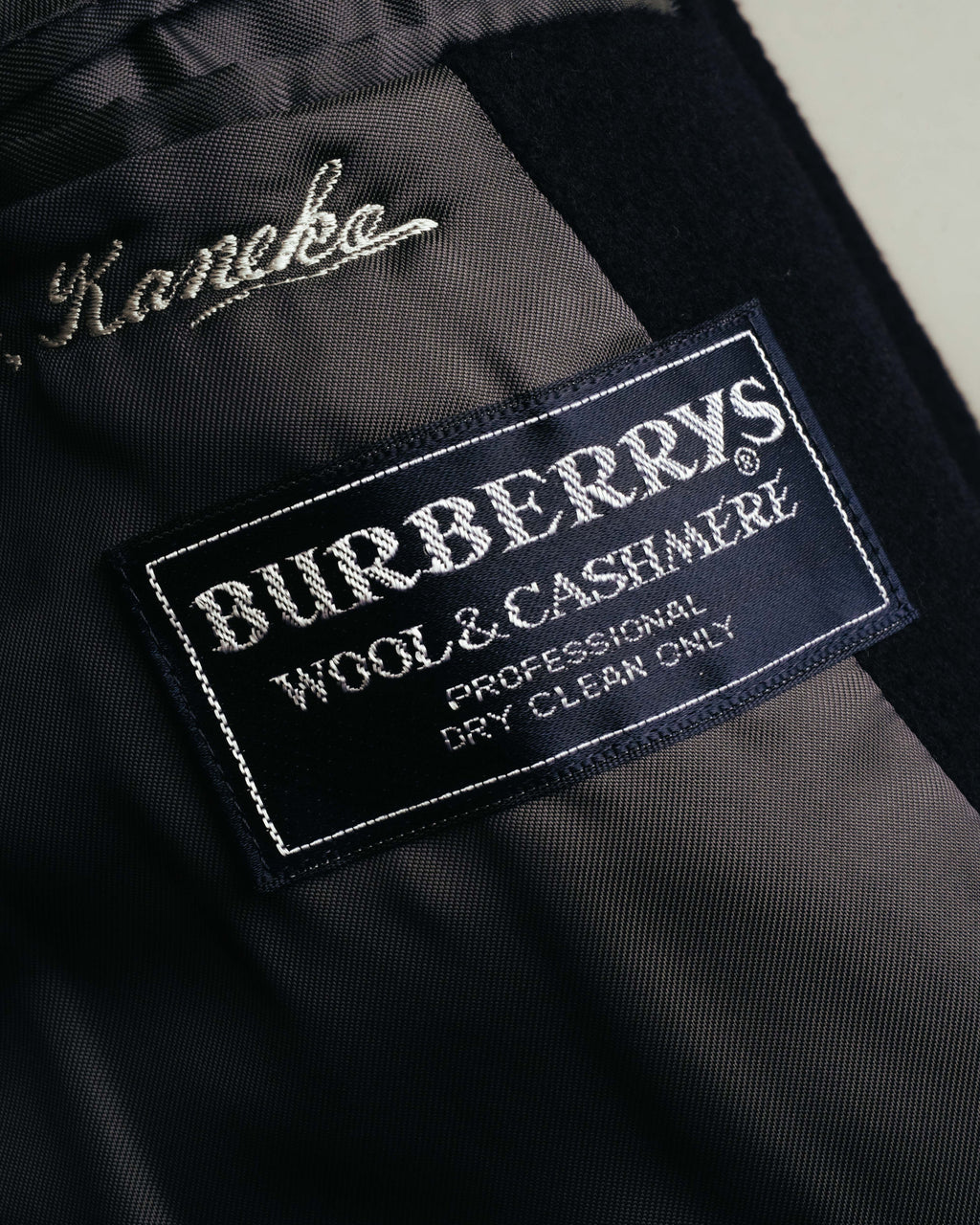 襟元に配された、騎馬騎士図案と「BURBERRYS」「WOOL & CASHMERE」表記が確認できる旧ネームタグのクローズアップ。