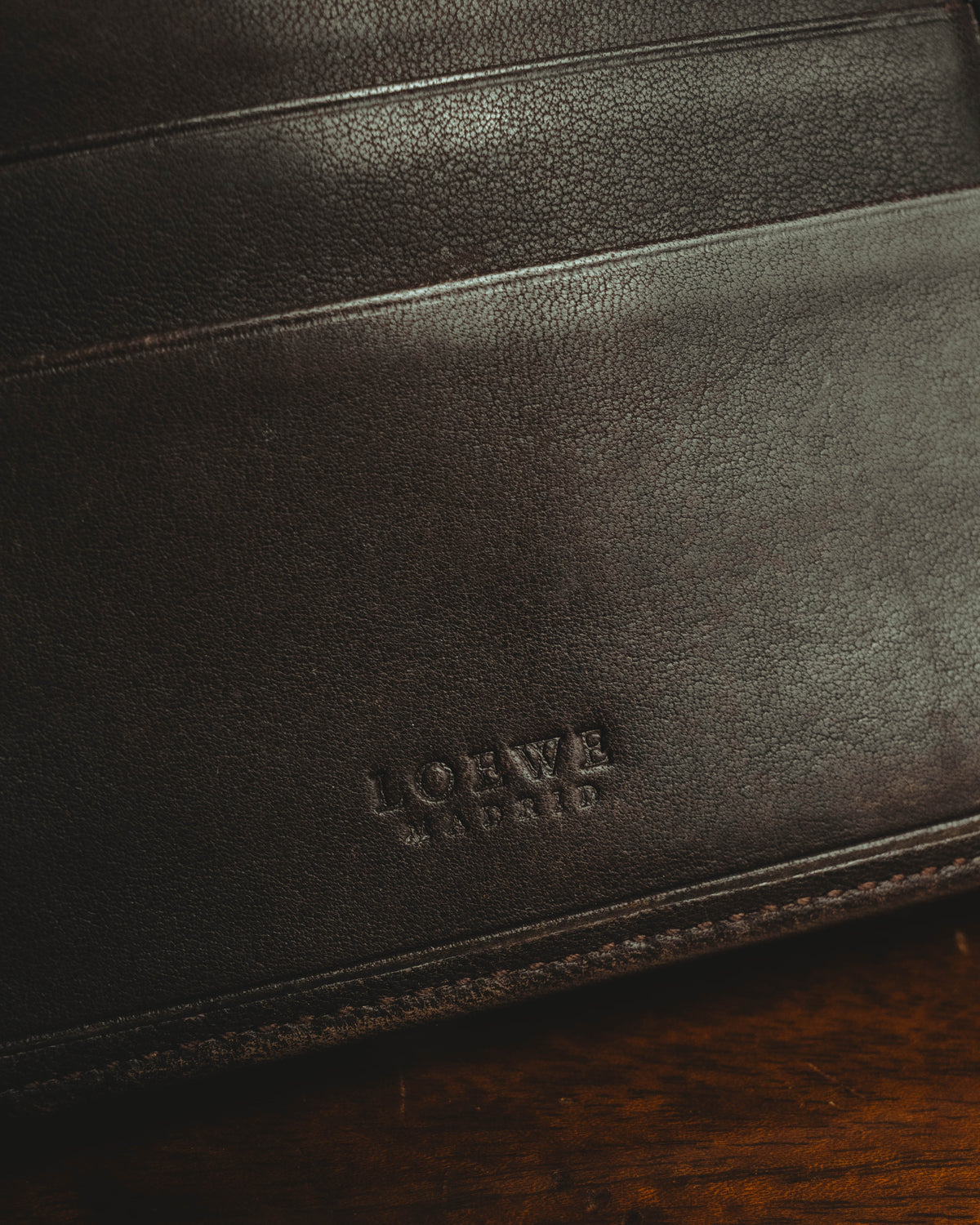 内装のきめ細かなシボを感じさせる革に、セリフ体のLOEWE MADRID刻印を配したディテール。上部には複数のカードスロットが確認できます。
