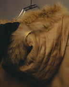 フード上部に施されたダイヤ状のキルティングと、輪郭を囲むベージュからブラウンへ移ろう毛足の長いファーのディテールカット。
