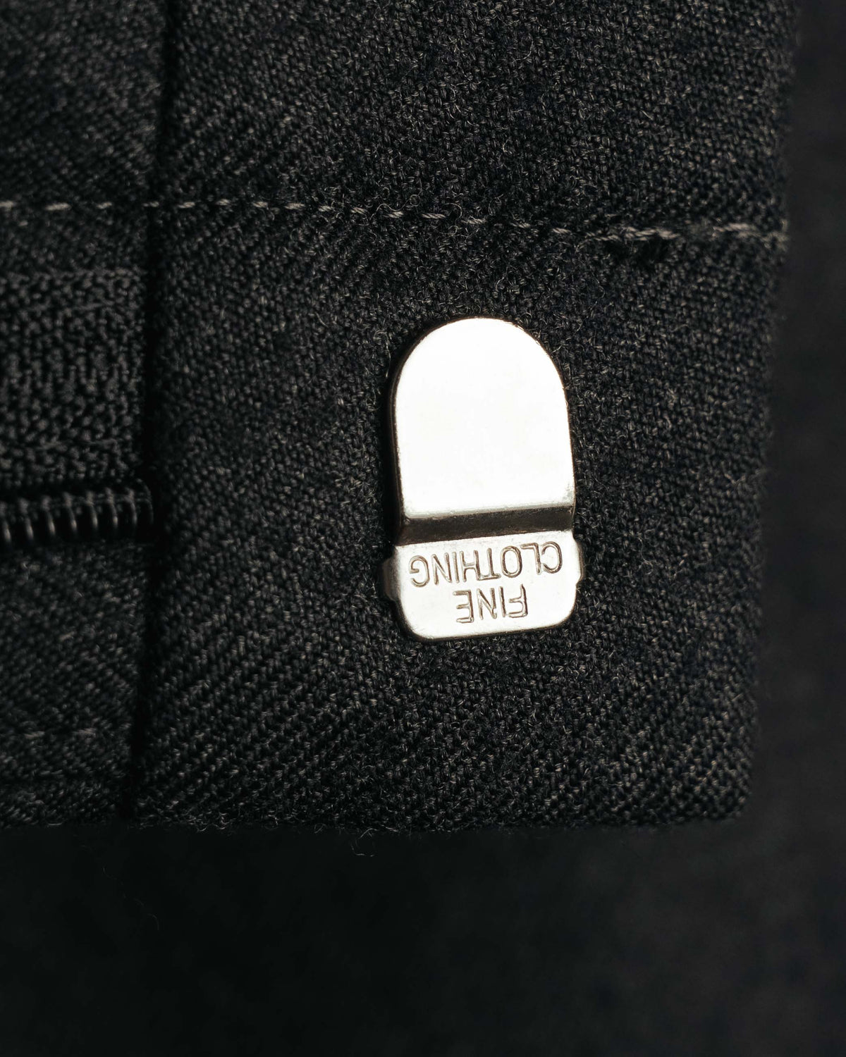 フロント開閉部に配された金属フックのディテール。フック表面には「FINE CLOTHING」の刻印が確認できます。