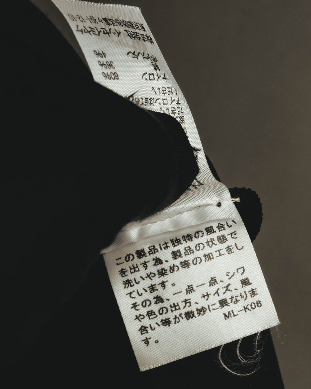 内側に配された洗濯表示タグと品質表示タグのクローズアップ。ナイロン・綿・ポリウレタンの混紡率と、日本語の取扱い表記が確認できるカットです。