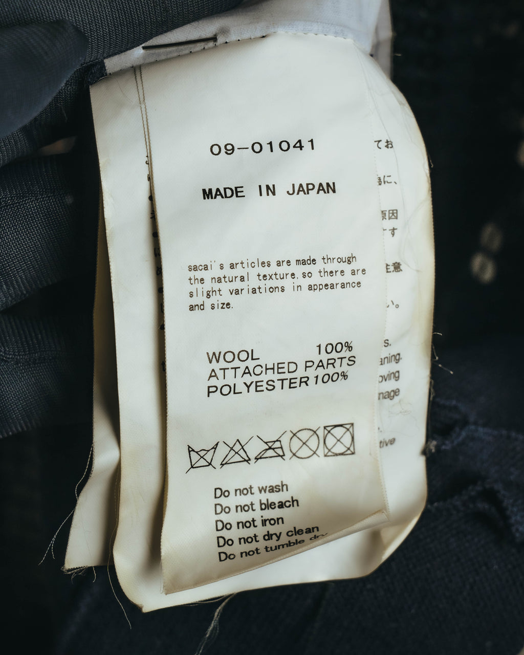 品番「09-01041」とMADE IN JAPAN表記が確認できる内側の品質表示タグ。素材表記はウール100%、別布ポリエステル100%となっています。