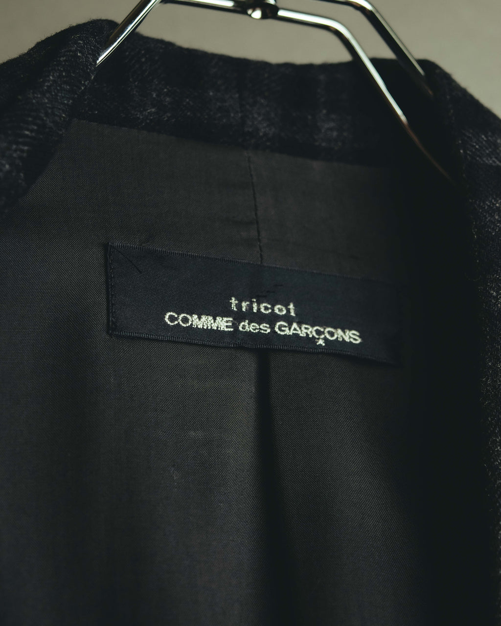 首元内側に配された旧型のtricot COMME des GARÇONSネームタグを捉えたカット。肩周りを中心に取り入れられたキュプラ裏地の仕様も確認できます。