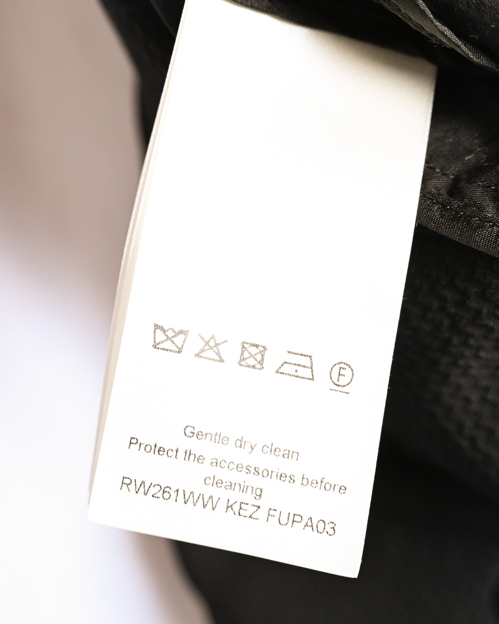 内側に配されたケアラベルのOCR確認カット。ドライクリーニング表記と品番「RW261WW KEZ FJPA03」が読み取れます。