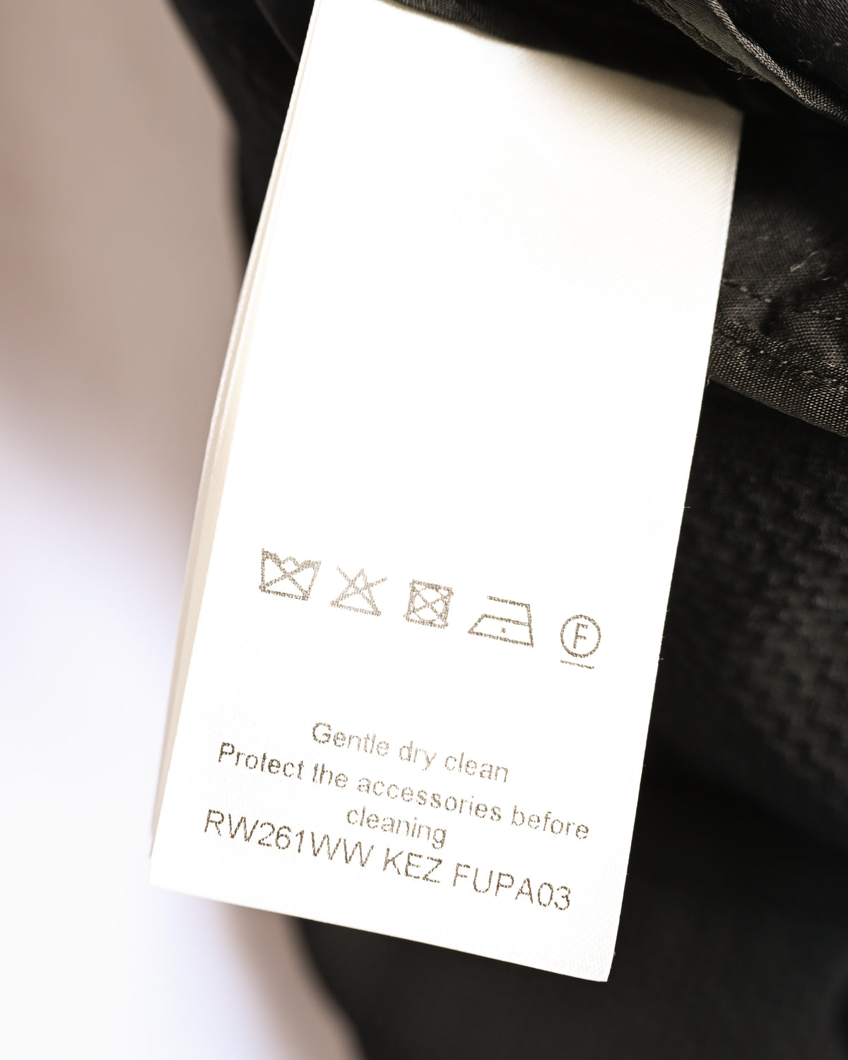 内側に配されたケアラベルのOCR確認カット。ドライクリーニング表記と品番「RW261WW KEZ FJPA03」が読み取れます。