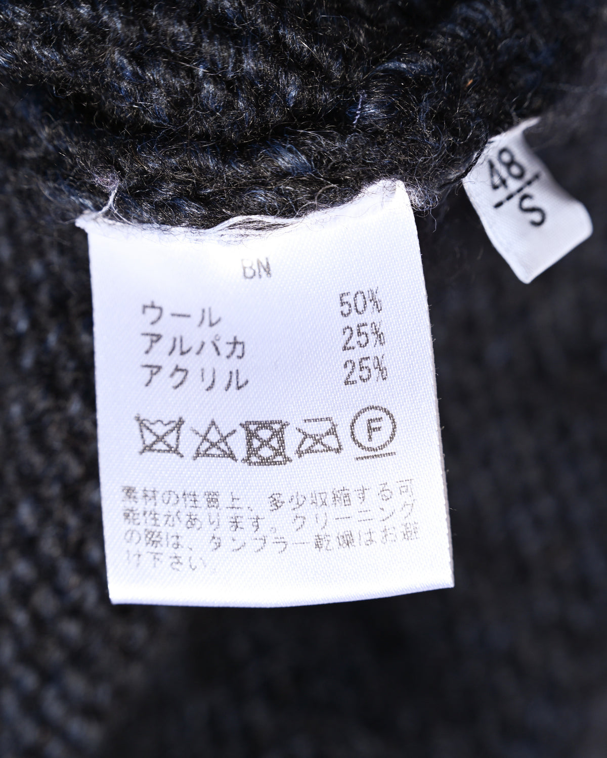 ウール50％・アルパカ25％・アクリル25％の混率とケア表示を確認できる内側の素材・洗濯表示タグ。サイズ表記は48／S。