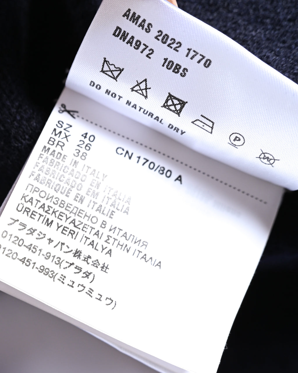 内タグに「AMAS 2022 1770」「DNA972」の表記、サイズ40、イタリア製、ウール100パーセントの素材表記が確認できるカット。洗濯表示もあわせて写しています。
